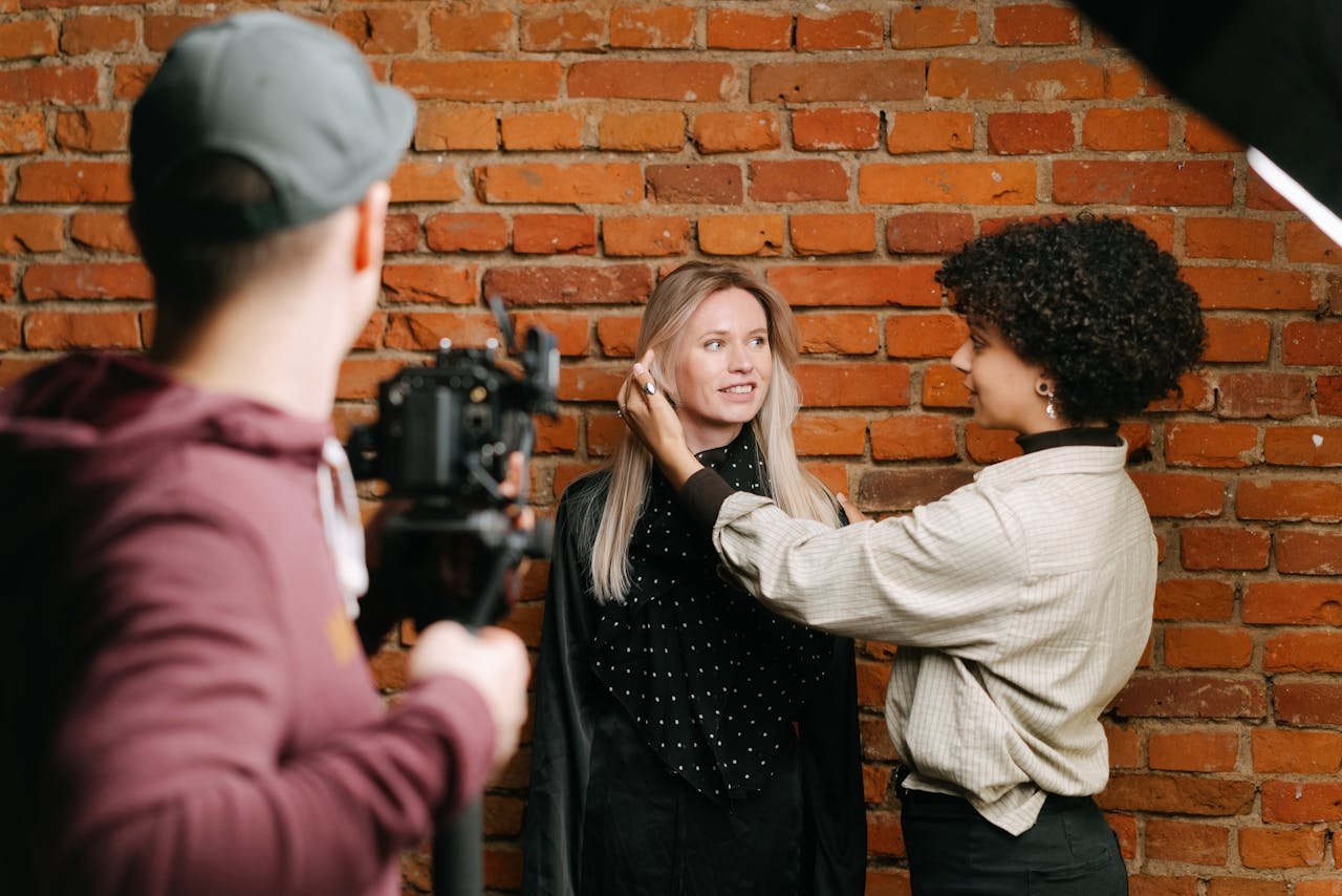 Diverse team at photoshoot setting up against a brick wall. Capturing fashion and style behind the scenes.